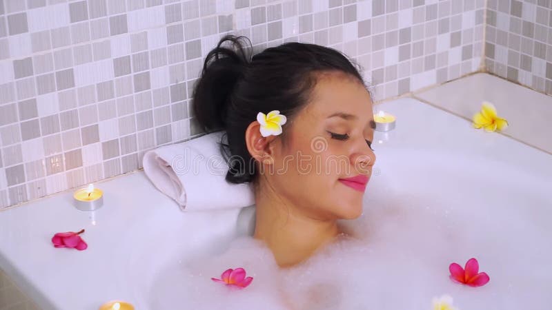 Schöne Asiatin, die auf Badewanne sich entspannt