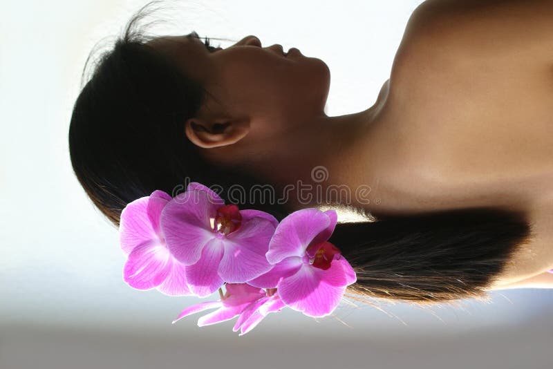Schöne asiatische Frau mit Orchideen auf Haar stockfoto Schöne asiatische Frau mit Orchideen auf Haar stockfoto