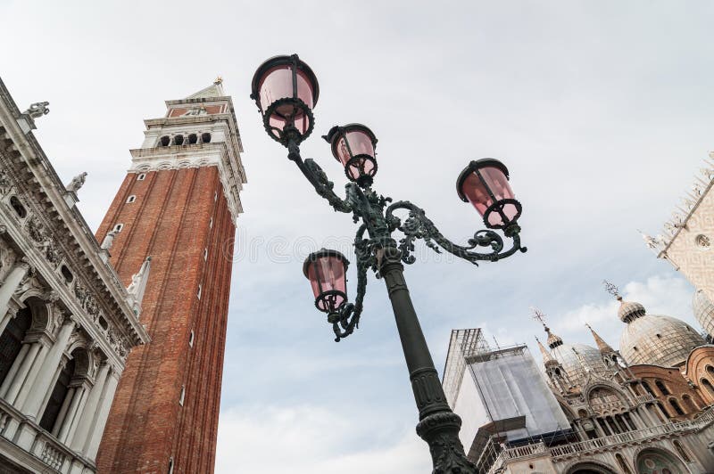 Schöne aufwändige Laternenpfähle im Marktplatz San Marco gegen Glockenturm lizenzfreies stockfoto Schöne aufwändige Laternenpfähle im Marktplatz San Marco gegen Glockenturm lizenzfreies stockfoto