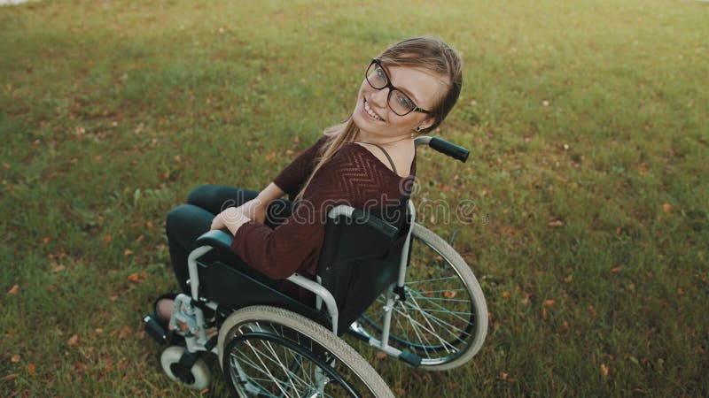 Schöne Behinderte kaukasischen Frau im Rollstuhl, der über die Schulter im Park sieht stock footage