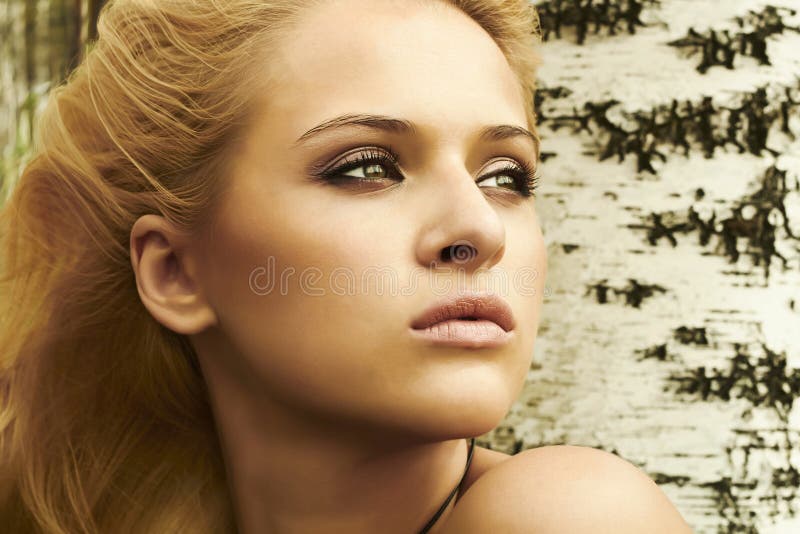 Schöne blonde Frau nahe einem Baum in einem Wald lizenzfreie stockfotografie Schöne blonde Frau nahe einem Baum in einem Wald lizenzfreie stockfotografie