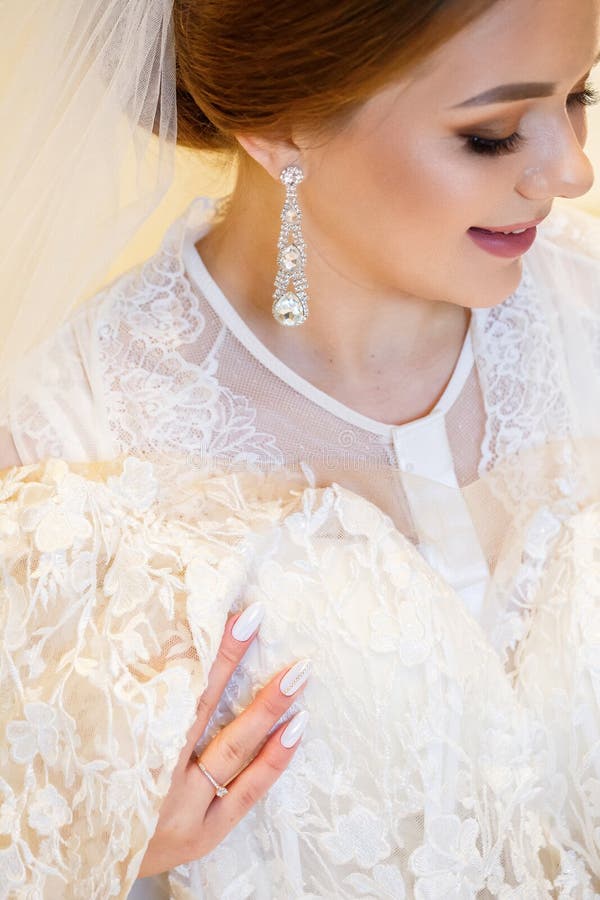 Schöne Brautkleidung mit ihrem weißen Hochzeitskleid lizenzfreie stockfotos