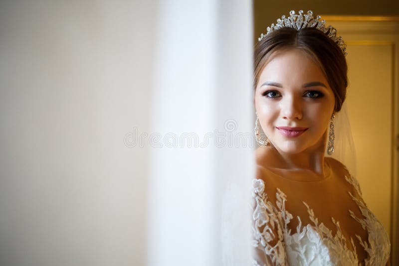 Schöne Brautkleidung mit ihrem weißen Hochzeitskleid lizenzfreie stockbilder