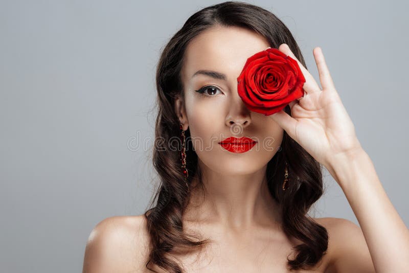 Schöne Brunettefrau mit rotem Lippenstift auf Lippen Nahaufnahmemädchen mit stieg lizenzfreies stockbild Schöne Brunettefrau mit rotem Lippenstift auf Lippen Nahaufnahmemädchen mit stieg lizenzfreies stockbild
