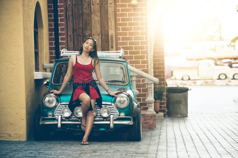 Schöne Dame Asiens, die nahe Retro- Auto steht lizenzfreie stockfotos Schöne Dame Asiens, die nahe Retro- Auto steht lizenzfreie stockfotos