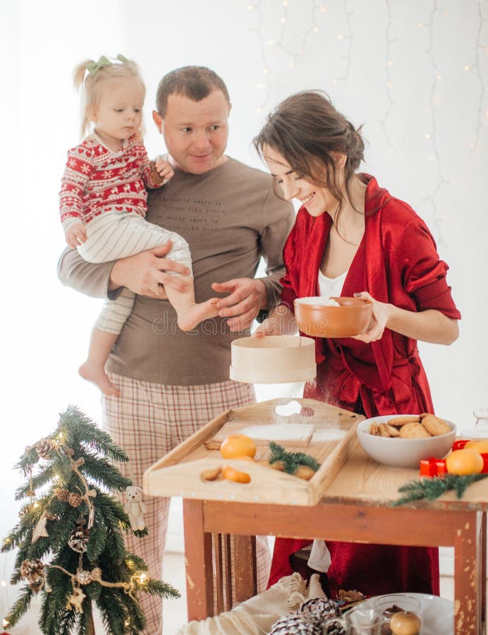 Schöne Familie mit dem Baby, das den Teig für die Torte zubereitet stockfoto Schöne Familie mit dem Baby, das den Teig für die Torte zubereitet stockfoto