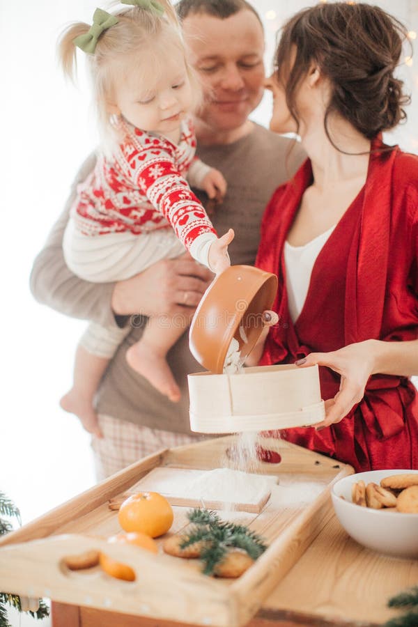 Schöne Familie mit dem Baby, das den Teig für die Torte zubereitet lizenzfreies stockfoto Schöne Familie mit dem Baby, das den Teig für die Torte zubereitet lizenzfreies stockfoto