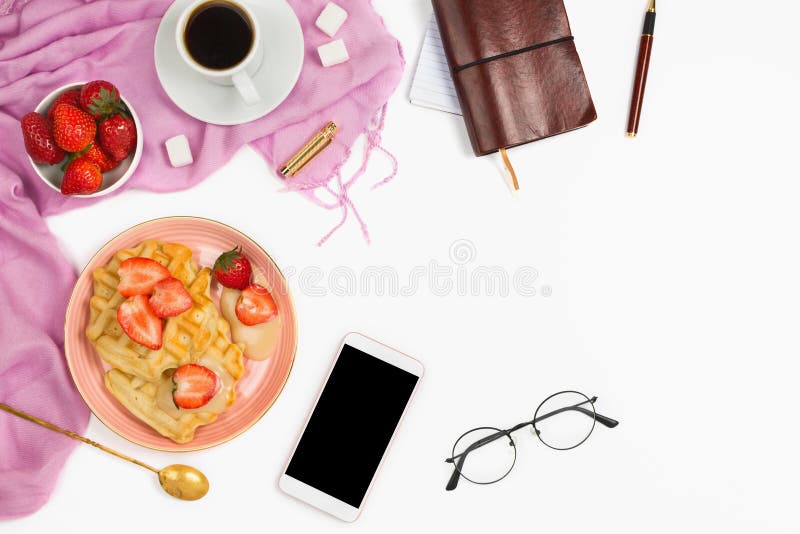 Schöne flatlay Anordnung mit Tasse Kaffee, heißen Waffeln mit Sahne und Erdbeeren, Gläsern und Zubehör des anderen Sektors: Konzept des beschäftigten Morgenfrühstücks, weißer Hintergrund