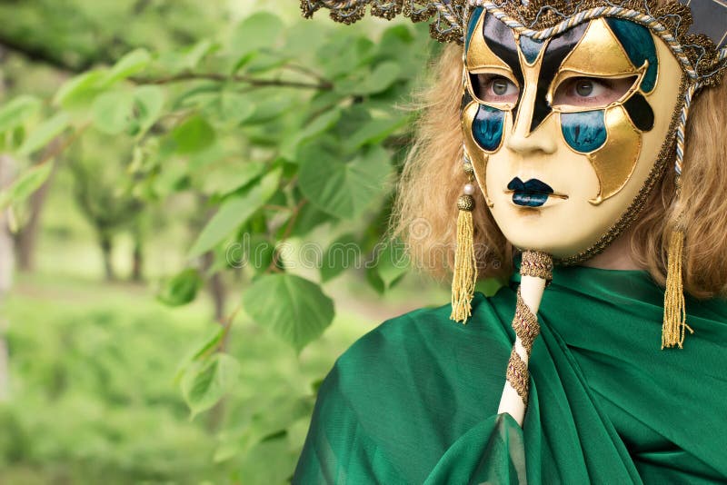 Beautiful woman in carnival mask over foliage background. Beautiful woman in carnival mask over foliage background