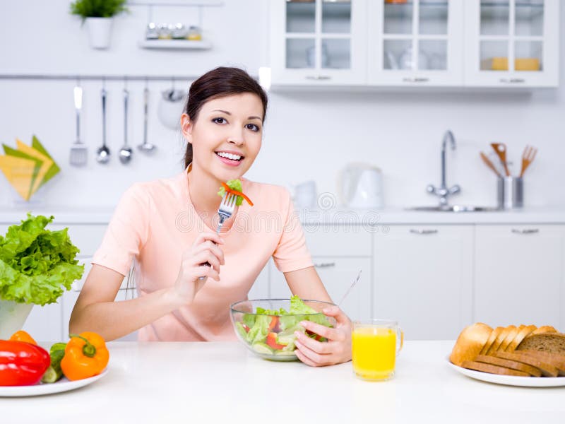Schöne Frau mit Nahrung in der Küche lizenzfreie stockfotografie Schöne Frau mit Nahrung in der Küche lizenzfreie stockfotografie
