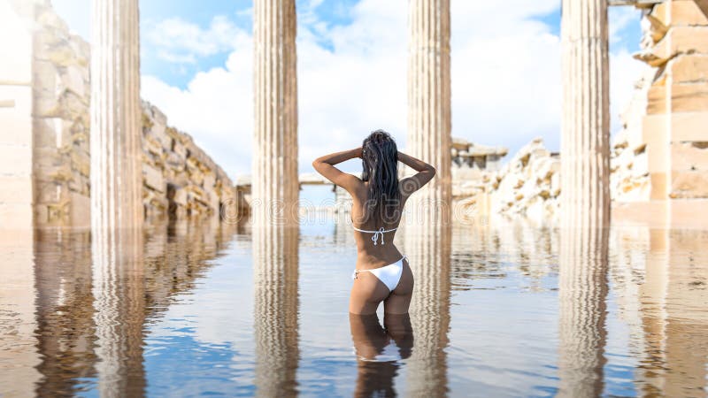Schöne Frau schwimmen im Wasser zwischen alten Tempelruinen lizenzfreie abbildung