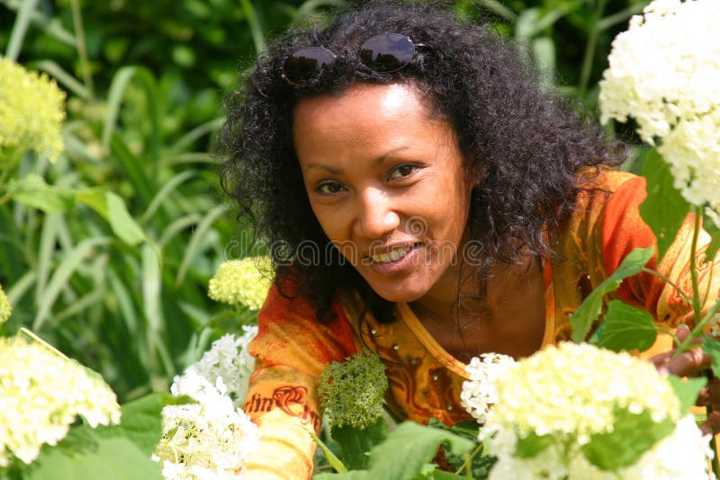 Beautiful surinam woman picking flowers in the garden. Beautiful surinam woman picking flowers in the garden