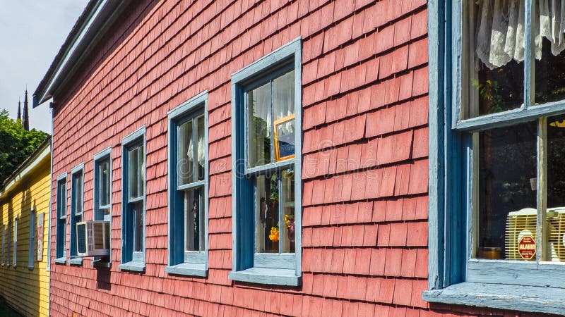 Schöne Gebäude mit blauen Fenstern auf der bunten Wand in Prinzen Edward Island, Kanada lizenzfreie stockfotos Schöne Gebäude mit blauen Fenstern auf der bunten Wand in Prinzen Edward Island, Kanada lizenzfreie stockfotos
