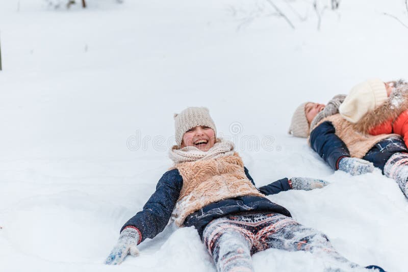 Schöne Jugendlichezwillingsschwestern, die Spaßaußenseite in einem Holz mit Schnee im Winter haben Freundschaft, Familie, Konzept stockbilder Schöne Jugendlichezwillingsschwestern, die Spaßaußenseite in einem Holz mit Schnee im Winter haben Freundschaft, Familie, Konzept stockbilder