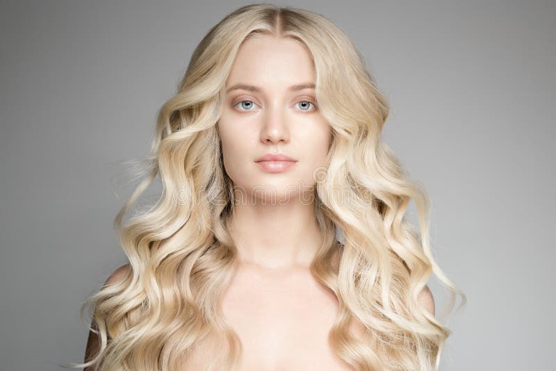 Schöne junge blonde Frau mit dem langen gewellten Haar