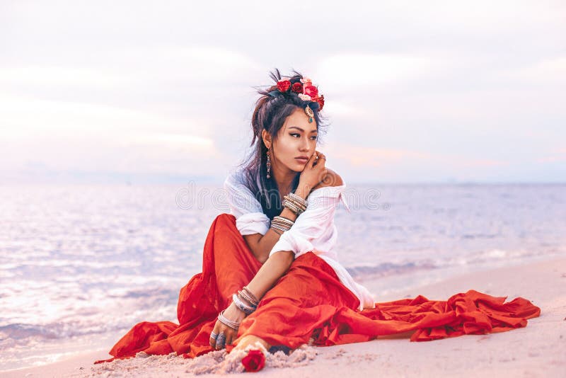 Schöne junge elegante boho Frau auf dem Strand bei Sonnenuntergang stockfotografie
