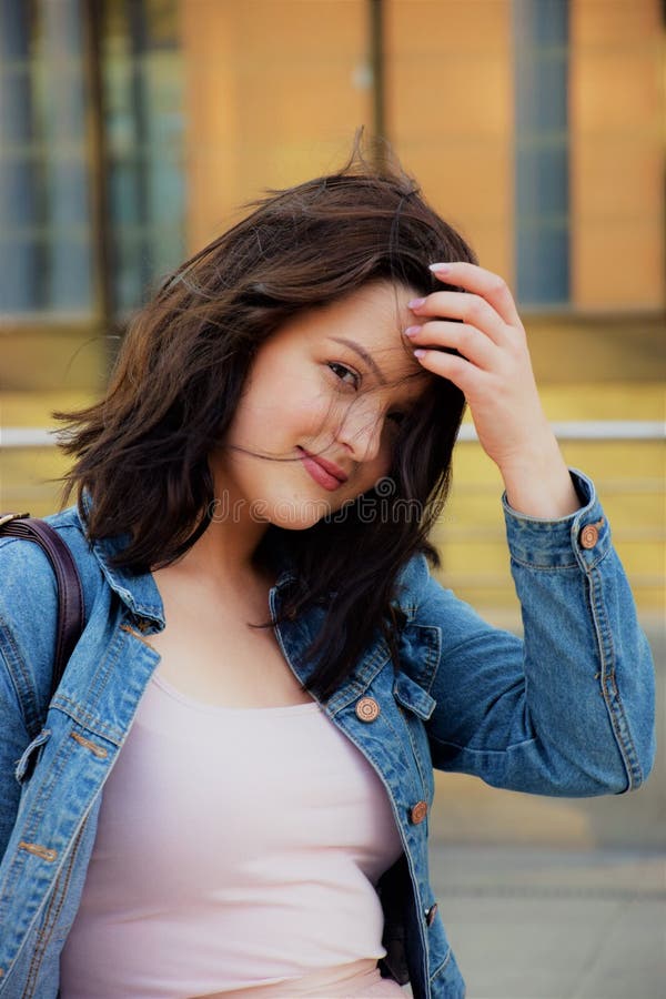 schöne junge elegante Frau in der Stadt, korrigiert ihr Haar lizenzfreies stockbild schöne junge elegante Frau in der Stadt, korrigiert ihr Haar lizenzfreies stockbild