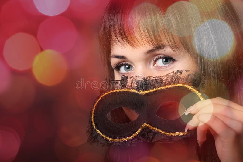 Beautiful young woman in carnival mask over blurred background. Beautiful young woman in carnival mask over blurred background