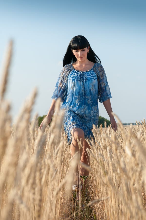 Schöne junge Frau in einem blauen Kleid stockfotografie Schöne junge Frau in einem blauen Kleid stockfotografie