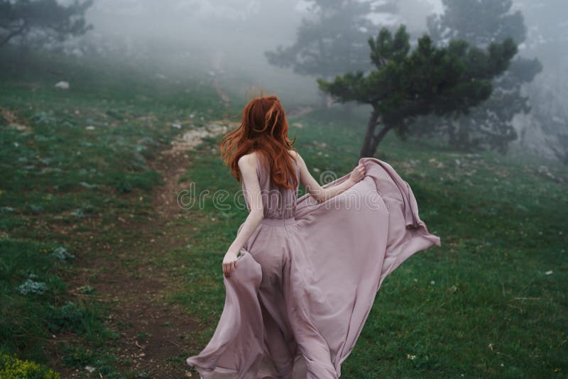 Schöne junge Frau in einem langen Kleid in den Bergen durch den Wald stockbilder Schöne junge Frau in einem langen Kleid in den Bergen durch den Wald stockbilder