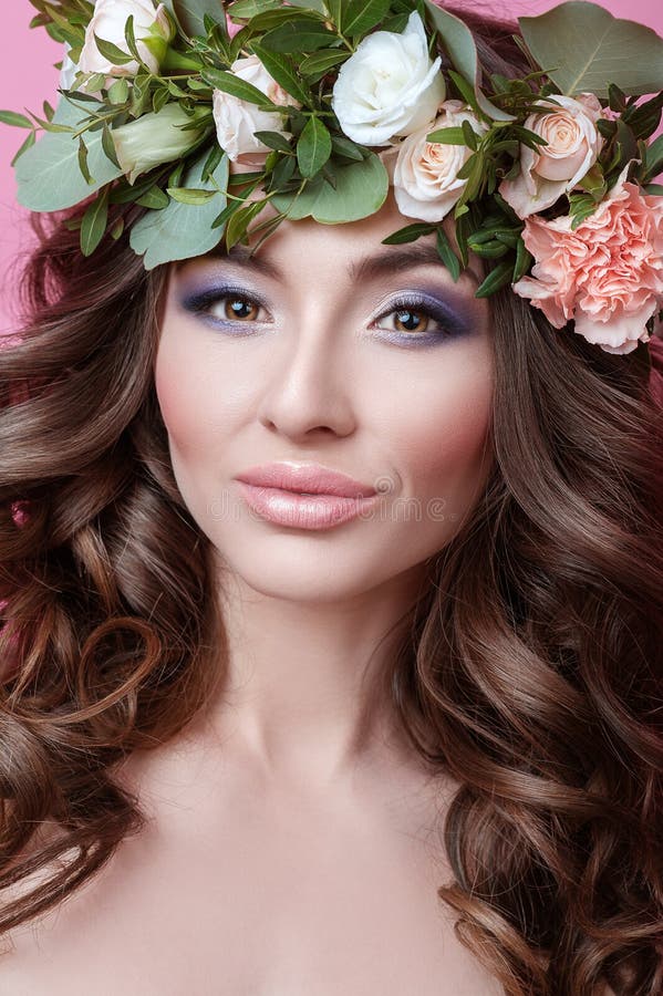 Schöne junge Frau mit dem gelockten Haar und Blume winden auf ihrem Kopf auf rosa Hintergrund Schönheitsmädchen mit der perfekten lizenzfreies stockbild Schöne junge Frau mit dem gelockten Haar und Blume winden auf ihrem Kopf auf rosa Hintergrund Schönheitsmädchen mit der perfekten lizenzfreies stockbild