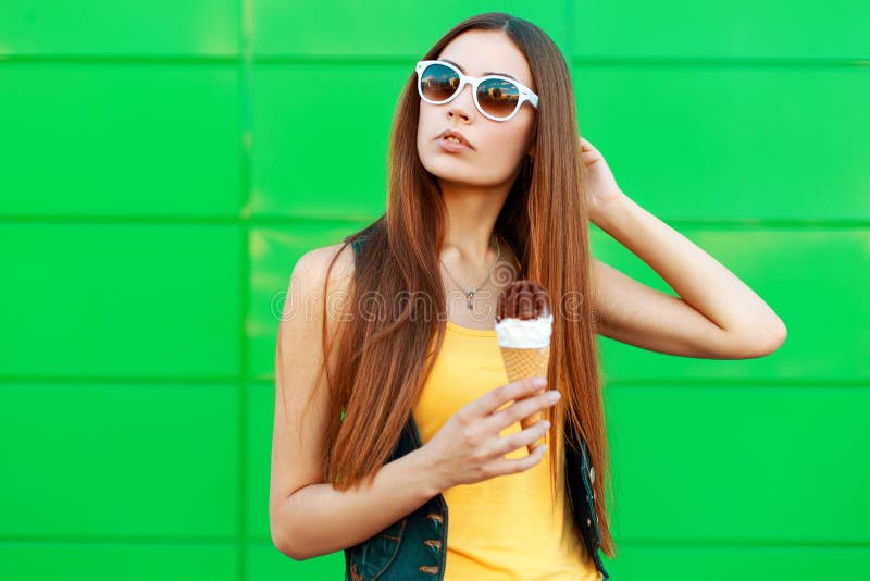 Schöne junge Frau mit Eiscreme in der Sonnenbrille steht lizenzfreie stockfotografie Schöne junge Frau mit Eiscreme in der Sonnenbrille steht lizenzfreie stockfotografie