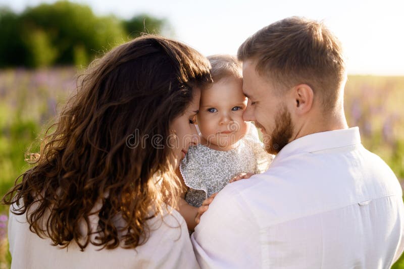Schöne junge kaukasische Familie Vater und Mutter umarmt ein hübsches Mädchen. schließen stockbild