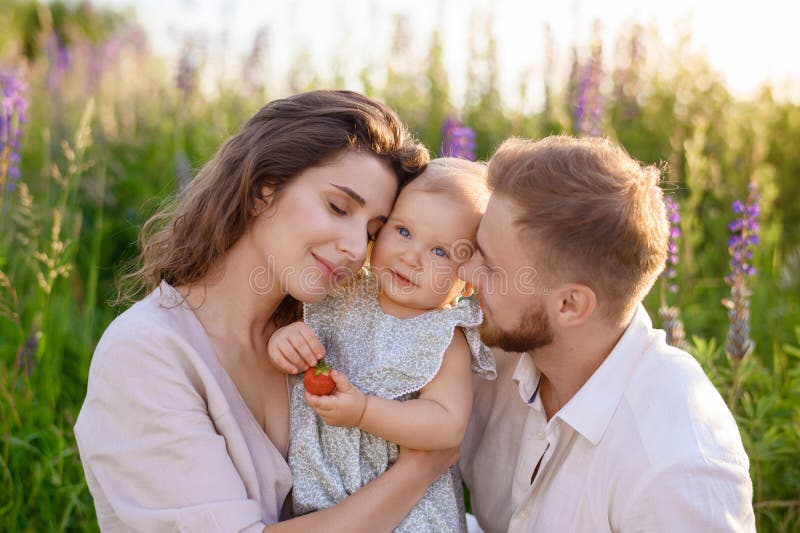 Schöne junge kaukasische Familie Vater und Mutter umarmt ein hübsches Mädchen lizenzfreies stockfoto