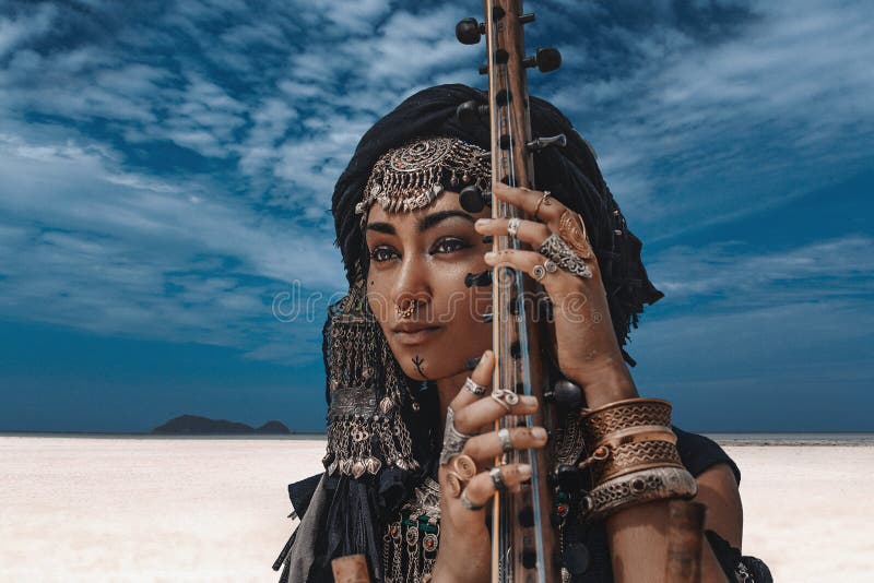 Schöne junge stilvolle Stammes- Frau im orientalischen Kostüm, das draußen Sitar spielt Abschluss oben