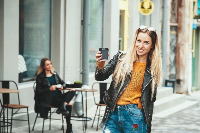 Schöne junge städtische Frau, die in der stilvollen Kaffeetasse haltenen und beim Gehen lächelnden Kleidung entlang die Straße tr stockfotos Schöne junge städtische Frau, die in der stilvollen Kaffeetasse haltenen und beim Gehen lächelnden Kleidung entlang die Straße tr stockfotos