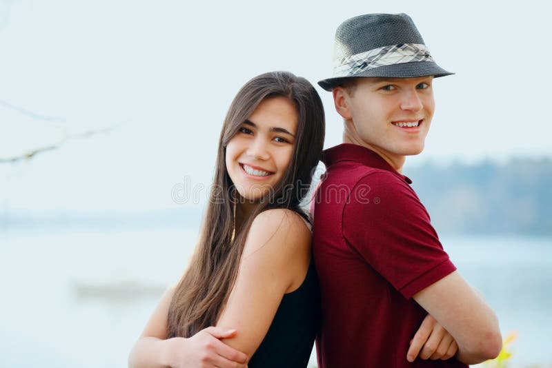 Schöne junge zwischen verschiedenen Rassen Paare, die zurück zu Rückseite stehen lizenzfreies stockfoto