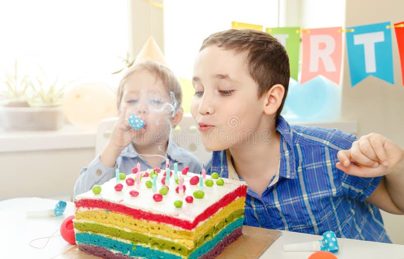 Schöne Kinder Geburtstag feiern und Kerzen auf Kuchen wehen lizenzfreie stockfotografie