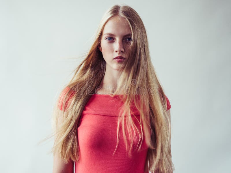 Beautiful long blonde hair woman in red dress natural over white background. Studio shot. Beautiful long blonde hair woman in red dress natural over white background. Studio shot