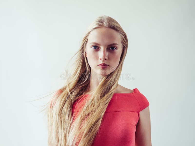 Beautiful long blonde hair woman in red dress natural over white background. Studio shot. Beautiful long blonde hair woman in red dress natural over white background. Studio shot