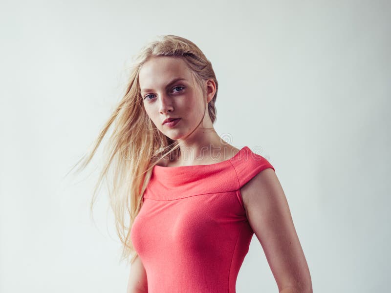 Beautiful long blonde hair woman in red dress natural over white background. Studio shot. Beautiful long blonde hair woman in red dress natural over white background. Studio shot