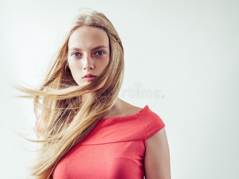 Beautiful long blonde hair woman in red dress natural over white background. Studio shot. Beautiful long blonde hair woman in red dress natural over white background. Studio shot