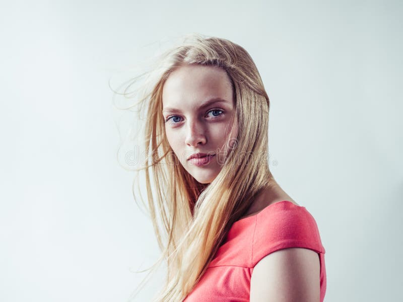 Beautiful long blonde hair woman in red dress natural over white background. Studio shot. Beautiful long blonde hair woman in red dress natural over white background. Studio shot