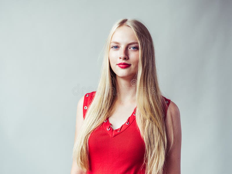 Beautiful long blonde hair woman in red dress natural over white background. Studio shot. Beautiful long blonde hair woman in red dress natural over white background. Studio shot