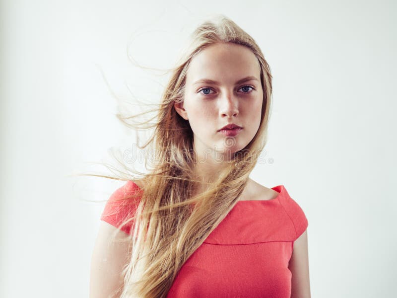 Beautiful long blonde hair woman in red dress natural over white background. Studio shot. Beautiful long blonde hair woman in red dress natural over white background. Studio shot