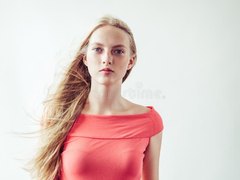 Beautiful long blonde hair woman in red dress natural over white background. Studio shot. Beautiful long blonde hair woman in red dress natural over white background. Studio shot