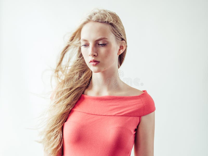 Beautiful long blonde hair woman in red dress natural over white background. Studio shot. Beautiful long blonde hair woman in red dress natural over white background. Studio shot