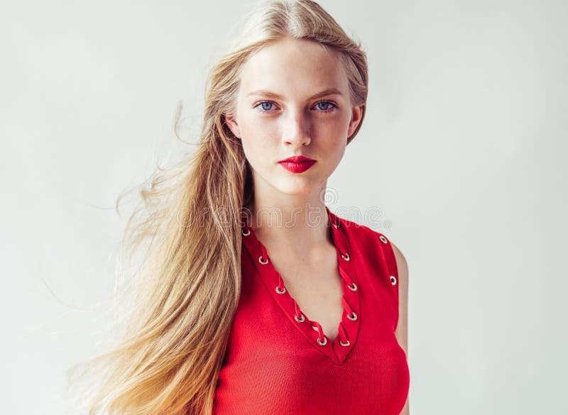 Beautiful long blonde hair woman in red dress natural over white background. Studio shot. Beautiful long blonde hair woman in red dress natural over white background. Studio shot