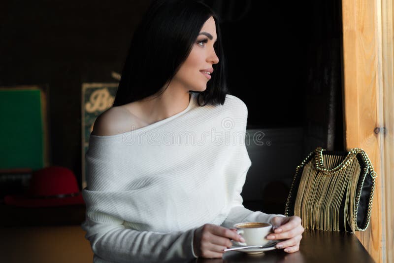 Schöne luxuriöse brunette Frau im Café lizenzfreie stockfotografie Schöne luxuriöse brunette Frau im Café lizenzfreie stockfotografie
