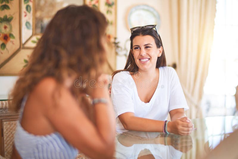 Schöne Mutter und Tochter, die zu Hause sprechen und lächeln