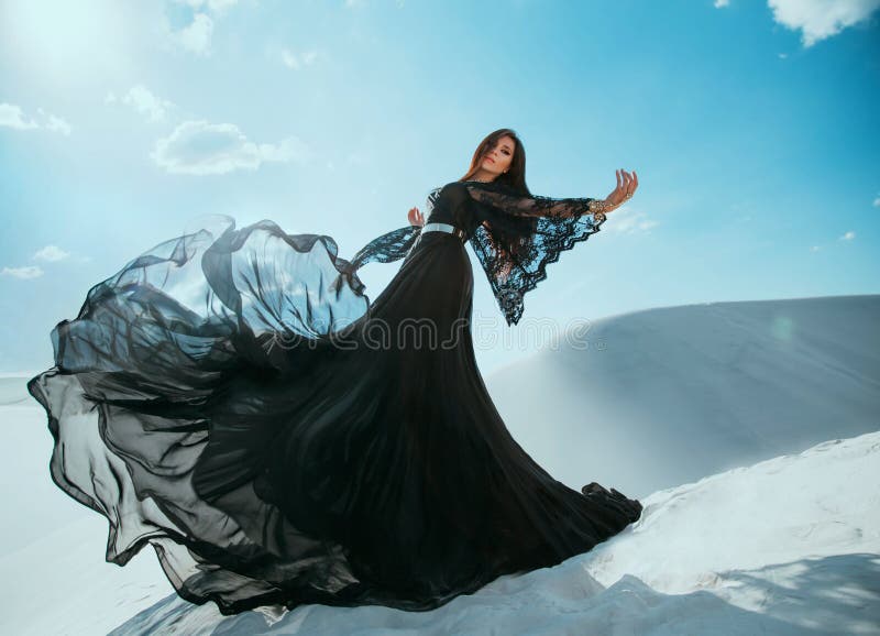 Schöne mysteriöse Arabische Frauenkönigin in der schwarzen Kleidung. Mädchenmode-modell, das Tanzen im langen Seidenkleidgewebe da
