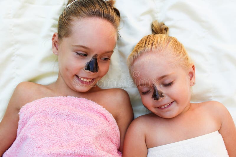 Schöne Mädchen mit schwarzer Lehmim gesichtmaske stockfotografie Schöne Mädchen mit schwarzer Lehmim gesichtmaske stockfotografie