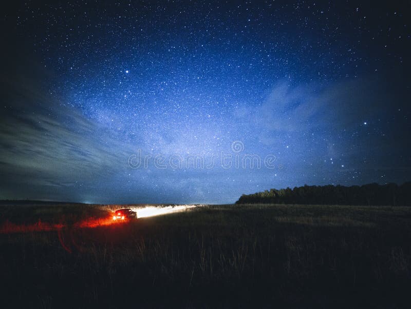 Schöne Nachtlandschaft mit Auto und Sternen stockbild Schöne Nachtlandschaft mit Auto und Sternen stockbild