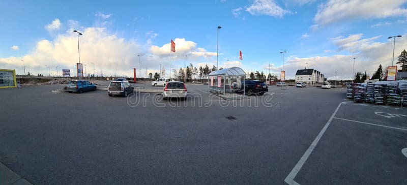 Schöne Panoramaansicht des Autoparkplatzes auf blauem Himmel mit weißem Wolkenhintergrund. Abstandsparkendes auto während Coronavirus Pandemie. Skandinavien. Schweden. Uppsala.