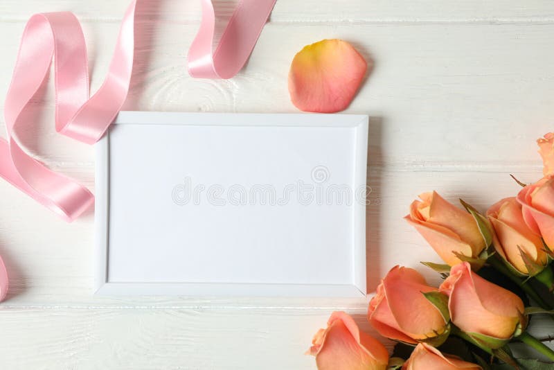 Schöne rosa Rosen, Band und leerer Rahmen auf hölzernem Hintergrund lizenzfreie stockfotos Schöne rosa Rosen, Band und leerer Rahmen auf hölzernem Hintergrund lizenzfreie stockfotos