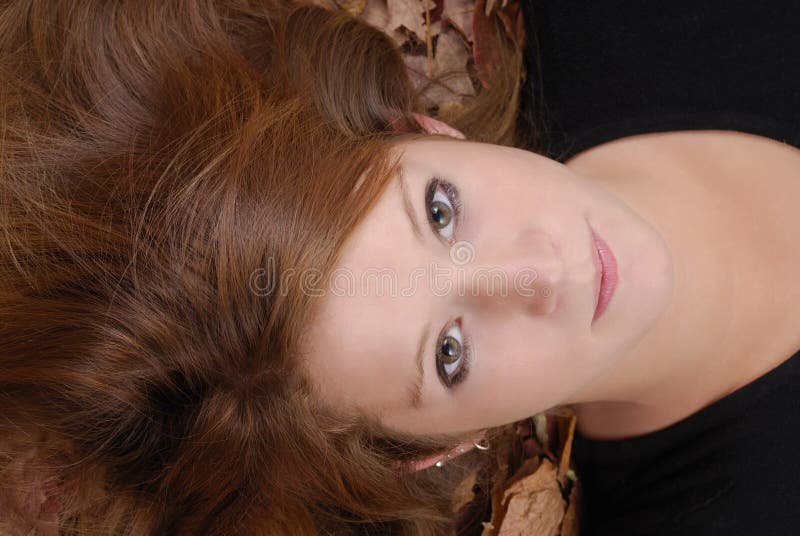 Schöne rote behaarte Frau in den Herbstblättern lizenzfreie stockfotografie Schöne rote behaarte Frau in den Herbstblättern lizenzfreie stockfotografie